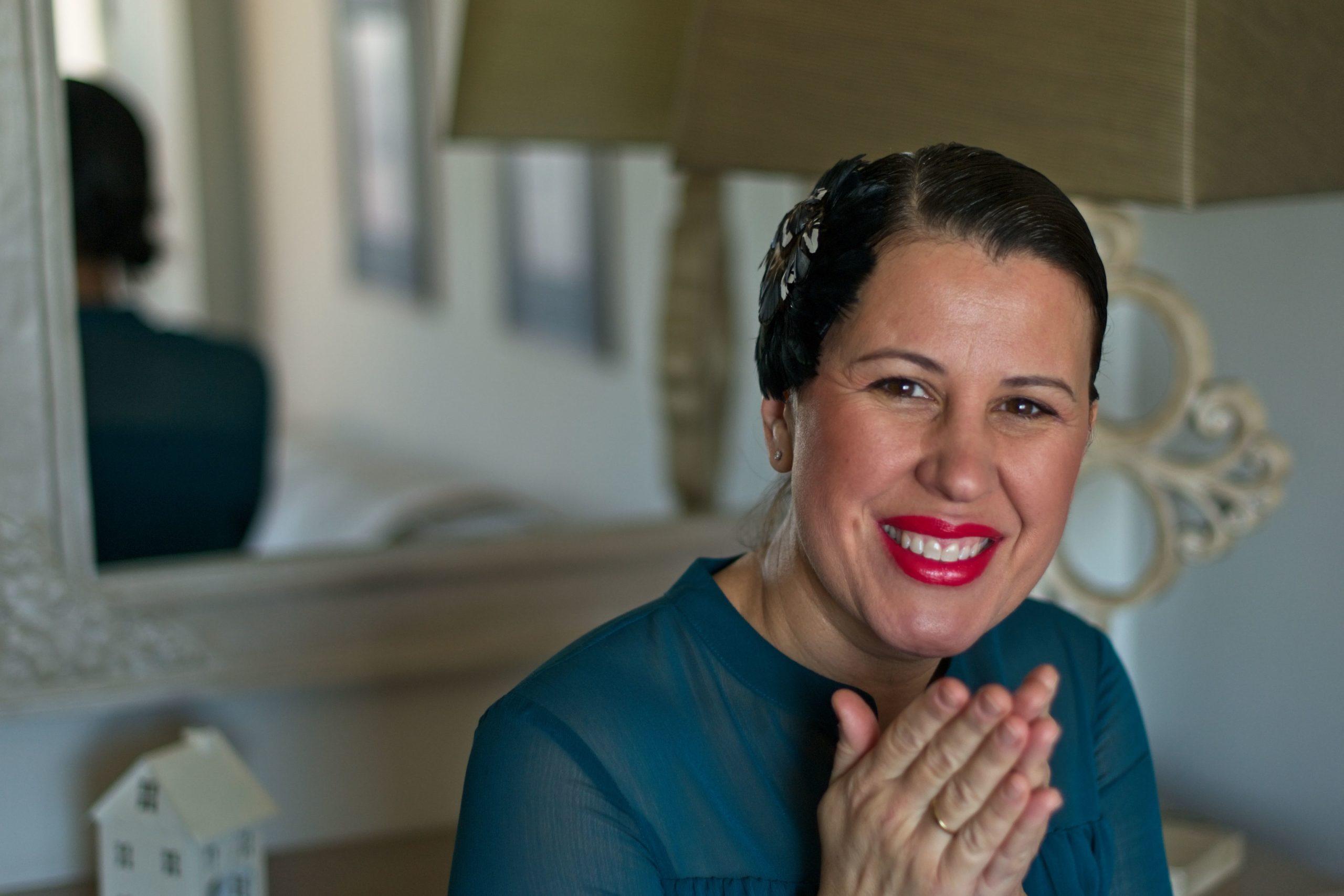 The founder of Bohemian Shoes, Eva Veiga, appears smiling. She wears her hair gelled and adorned with a black headdress.